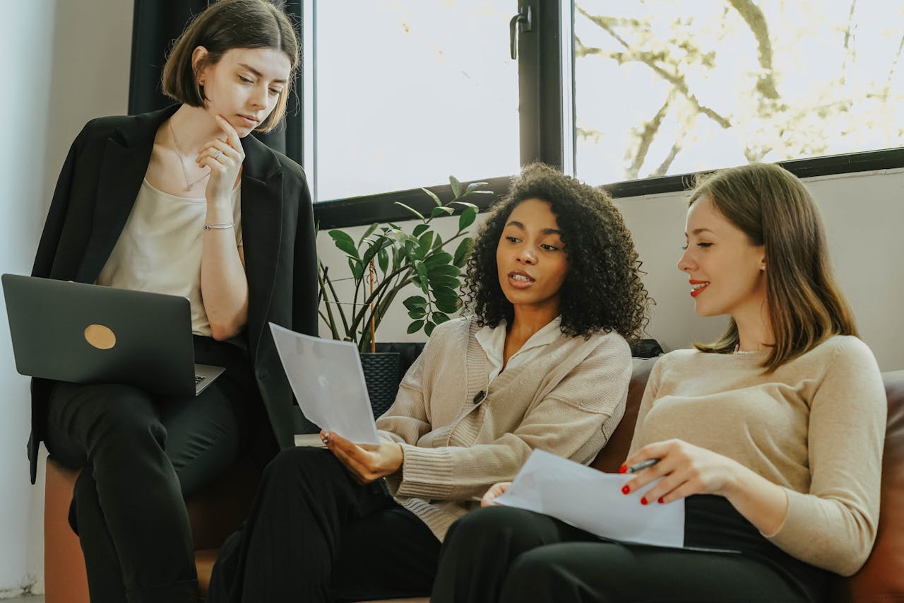 Women talking business while sitting on a sofa. Business grants for women in Texas.