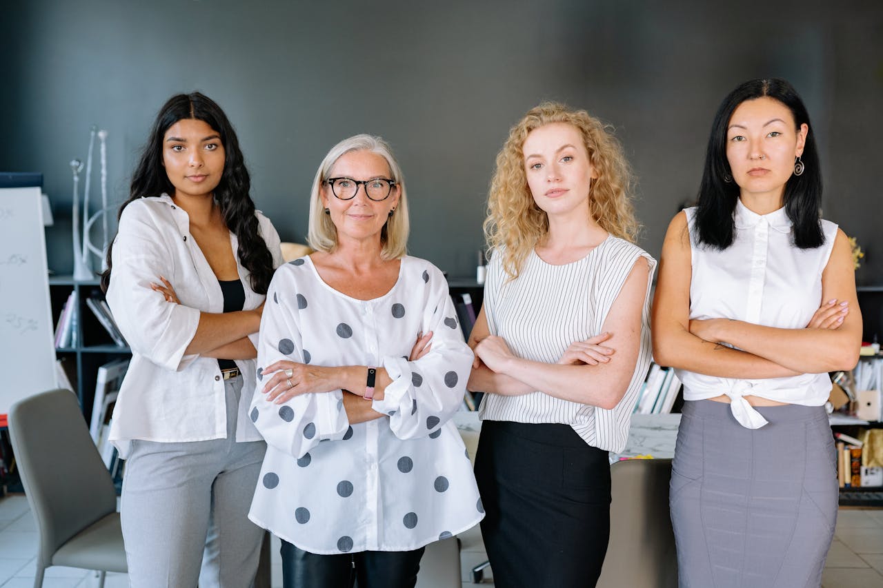 Four women standing together in an office. Business grants and resources for women in Salt Lake City, Utah.