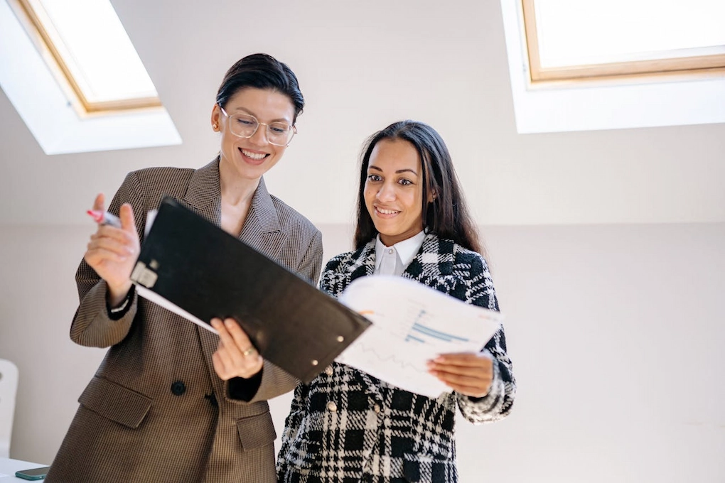 Women looking at a document in the office. Business grants for women in Maine