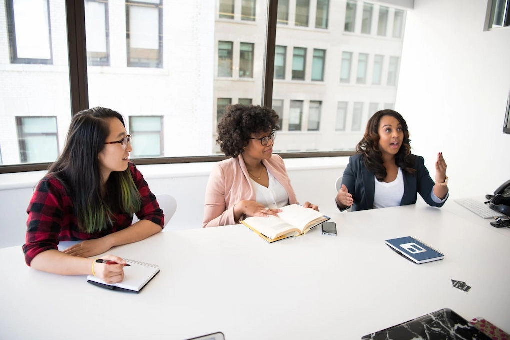 Three women sitting in front a desk. Business grants for women in South Carolina