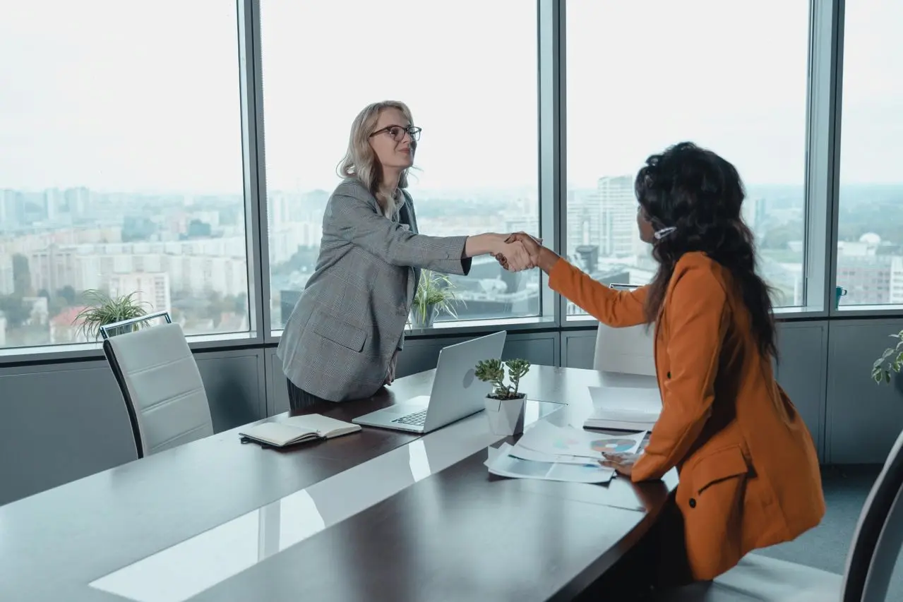 Two businesswomen shaking hands. How to build relationships with business grant providers.