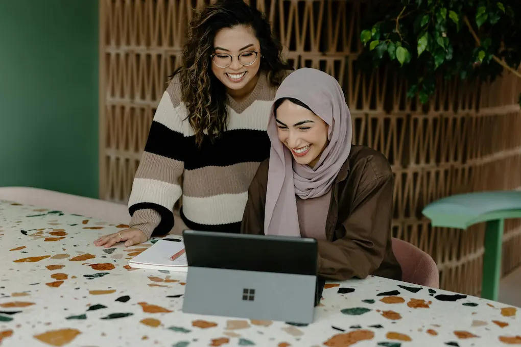 Women sitting at a table with a laptop. America’s Seed Fund SBIR/STTR