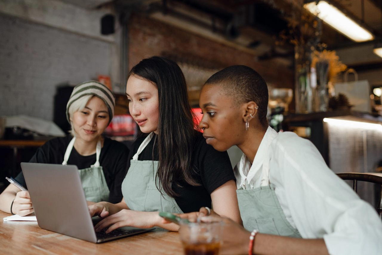 Three women working together in an office. Visa She’s Next Grant Program