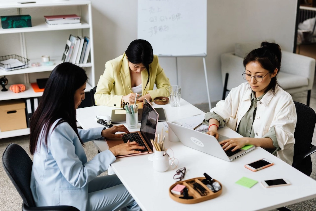 Three women working together. Can you use a business grant to pay yourself?