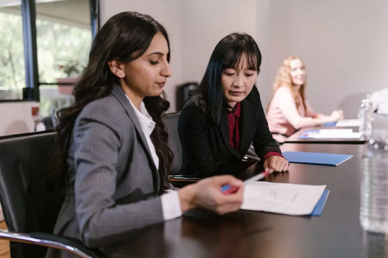 To corporate women reviewing a document. Monthly Business Grants for Women