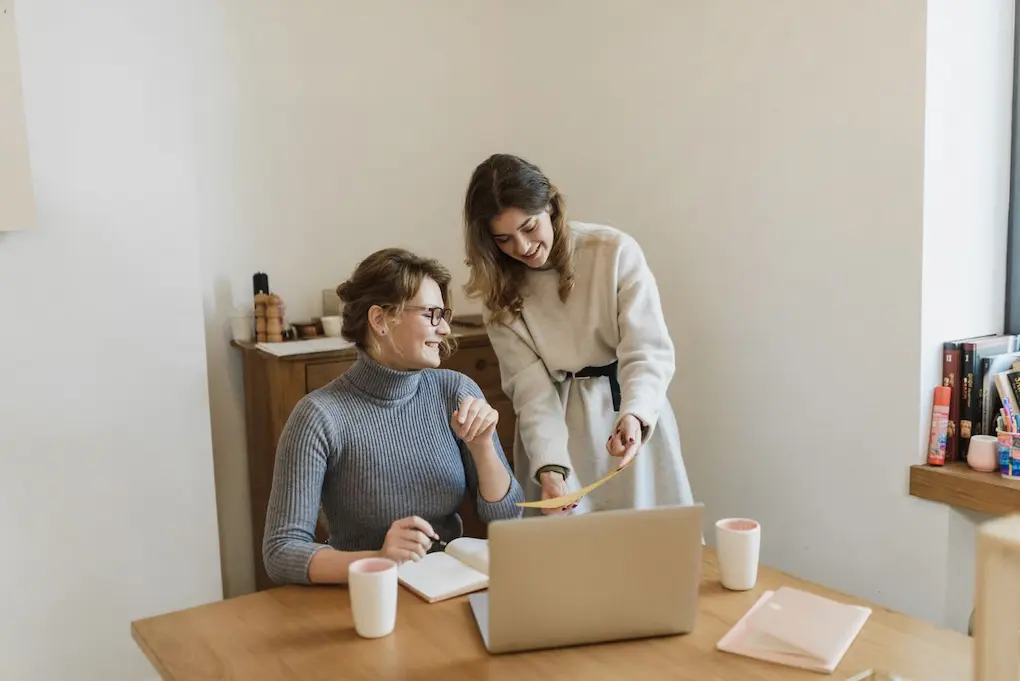 Two women discussing a project with a laptop in a bright, modern office. Funding opportunities for women entrepreneurs in Kentucky
